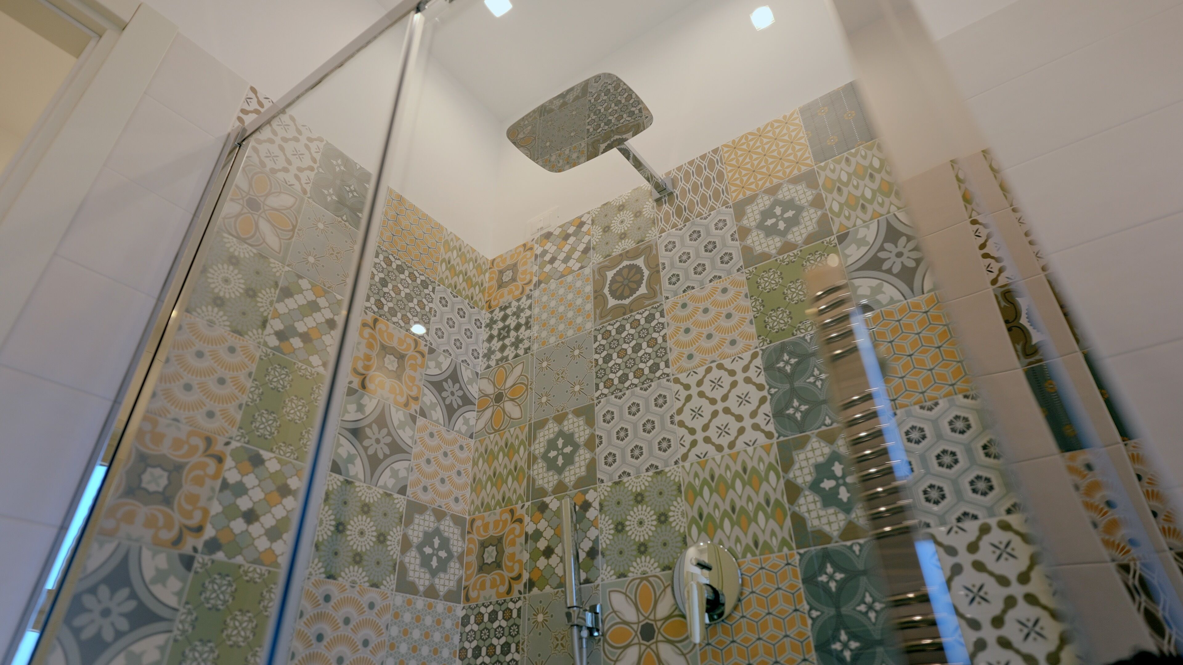 Een douche met een glazen deur en een plafondventilator.