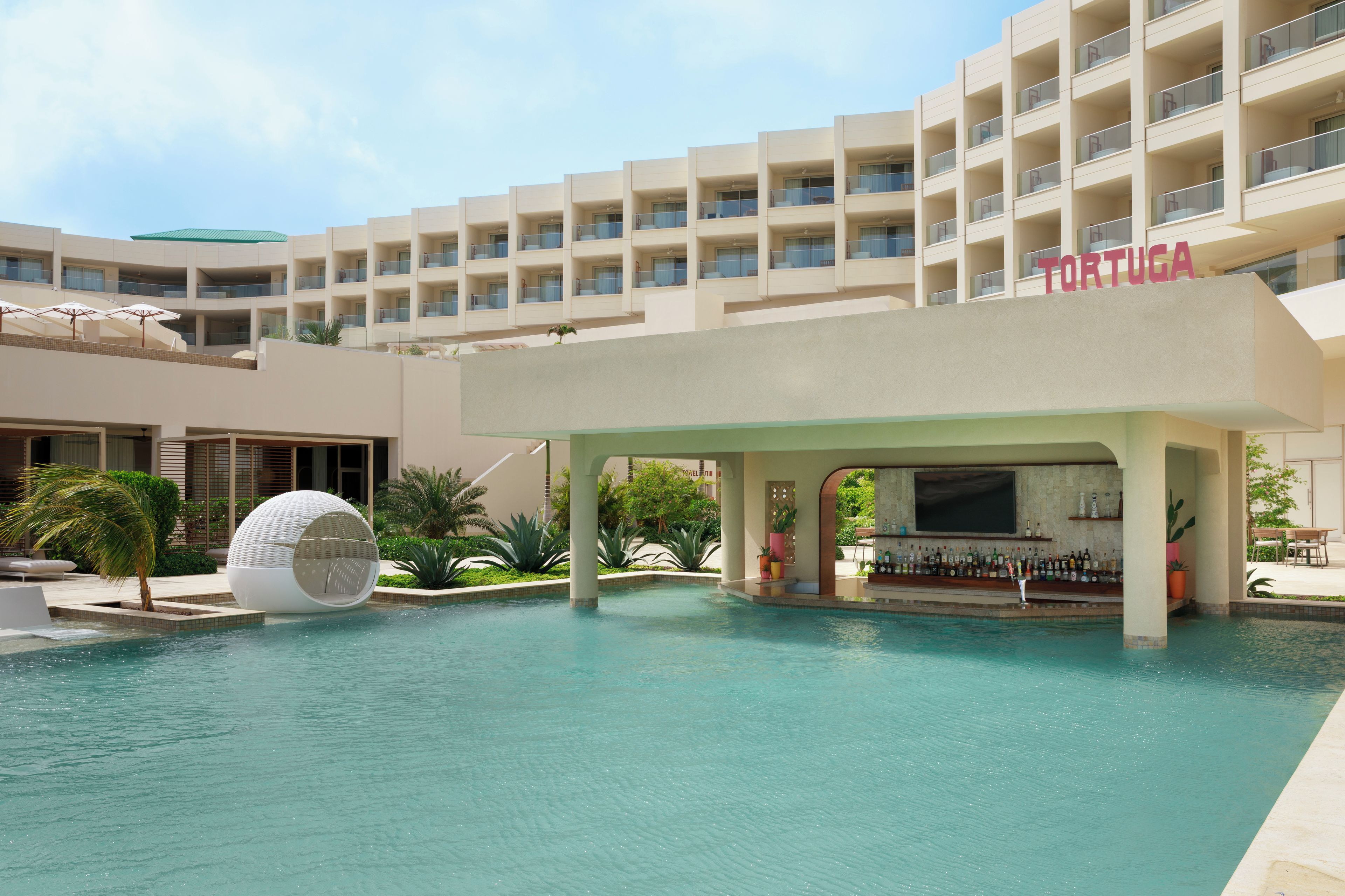A resort with a swimming pool, a covered bar area, and a building labeled 'TORTUGA'.