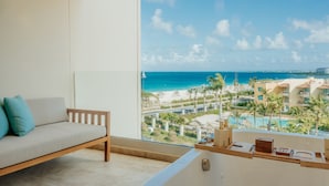A balcony with a view of the ocean and resort buildings.