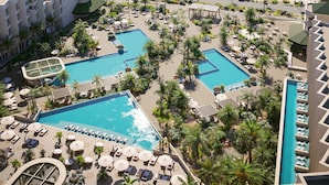 A resort with multiple swimming pools, a beach, and a view of the ocean.