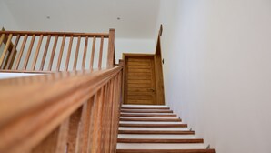 A wooden staircase with white steps leading to a wooden door at the top. - Lagati Residence (Mahé Island)
