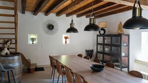 Un comedor con mesa de madera, sillas e iluminación colgante.