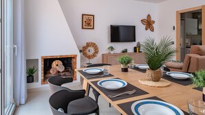 A modern dining area with a fireplace, a flat-screen TV, and a sofa. - Beachfront Family Retreat with Stunning Sea Views in Palamós (Palamós)