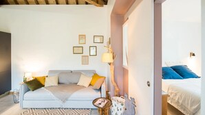 A cozy room with a sofa, a small table, and a bed. - Château de la Malmaison (103859379) (Aÿ-Champagne)