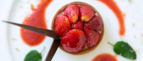 Un postre con fresas y una cuchara.