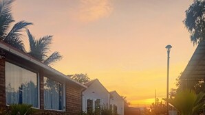 A residential area with houses, a paved walkway, and palm trees. - Chan Beach Resort (Bahur)