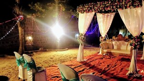 A beachside wedding setup with white chairs and draped white fabric. - Chan Beach Resort (Bahur)