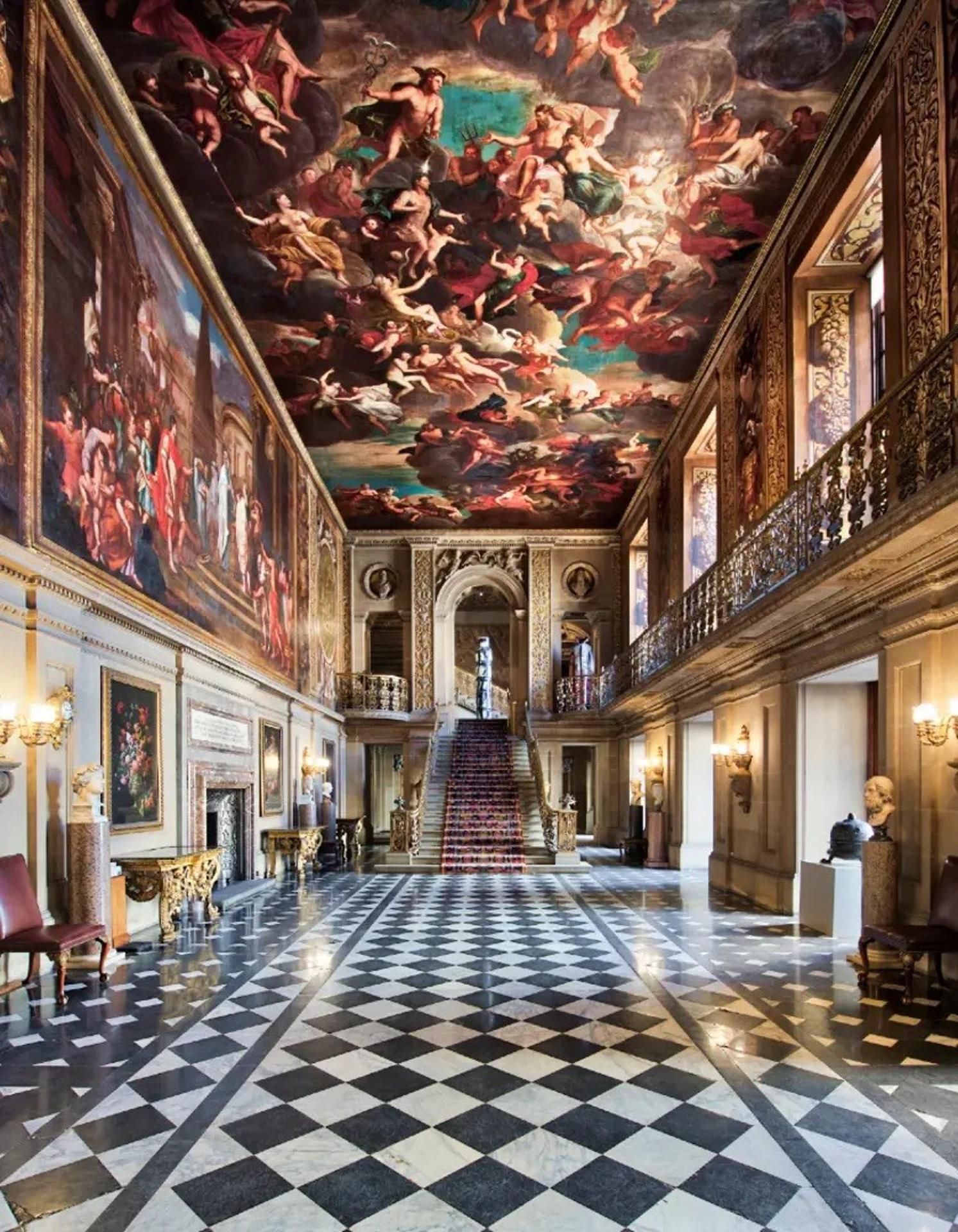 A grand hall with a checkered floor, ornate ceiling frescoes, and classical architecture.