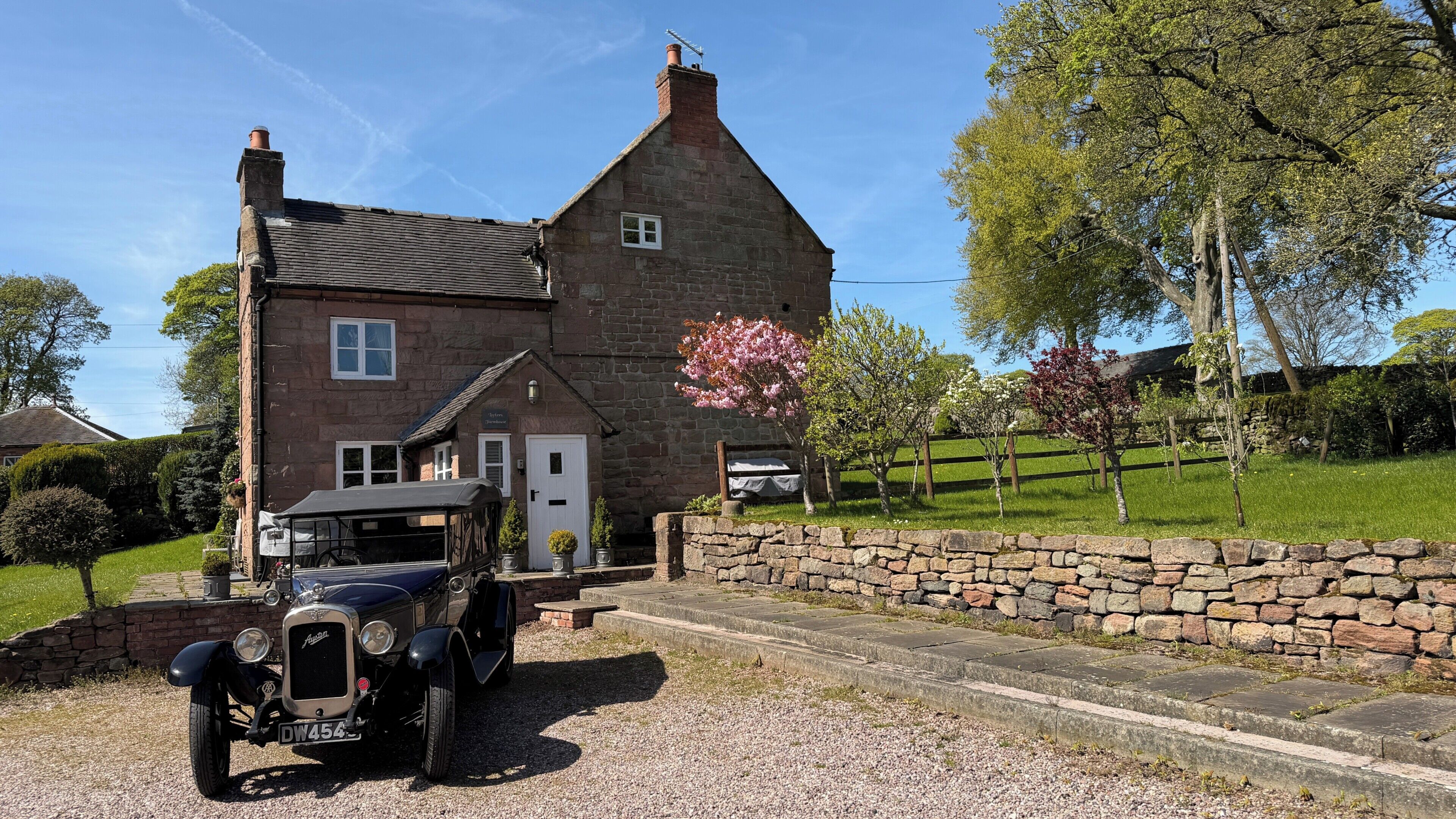 A stone house with a car parked in front.
