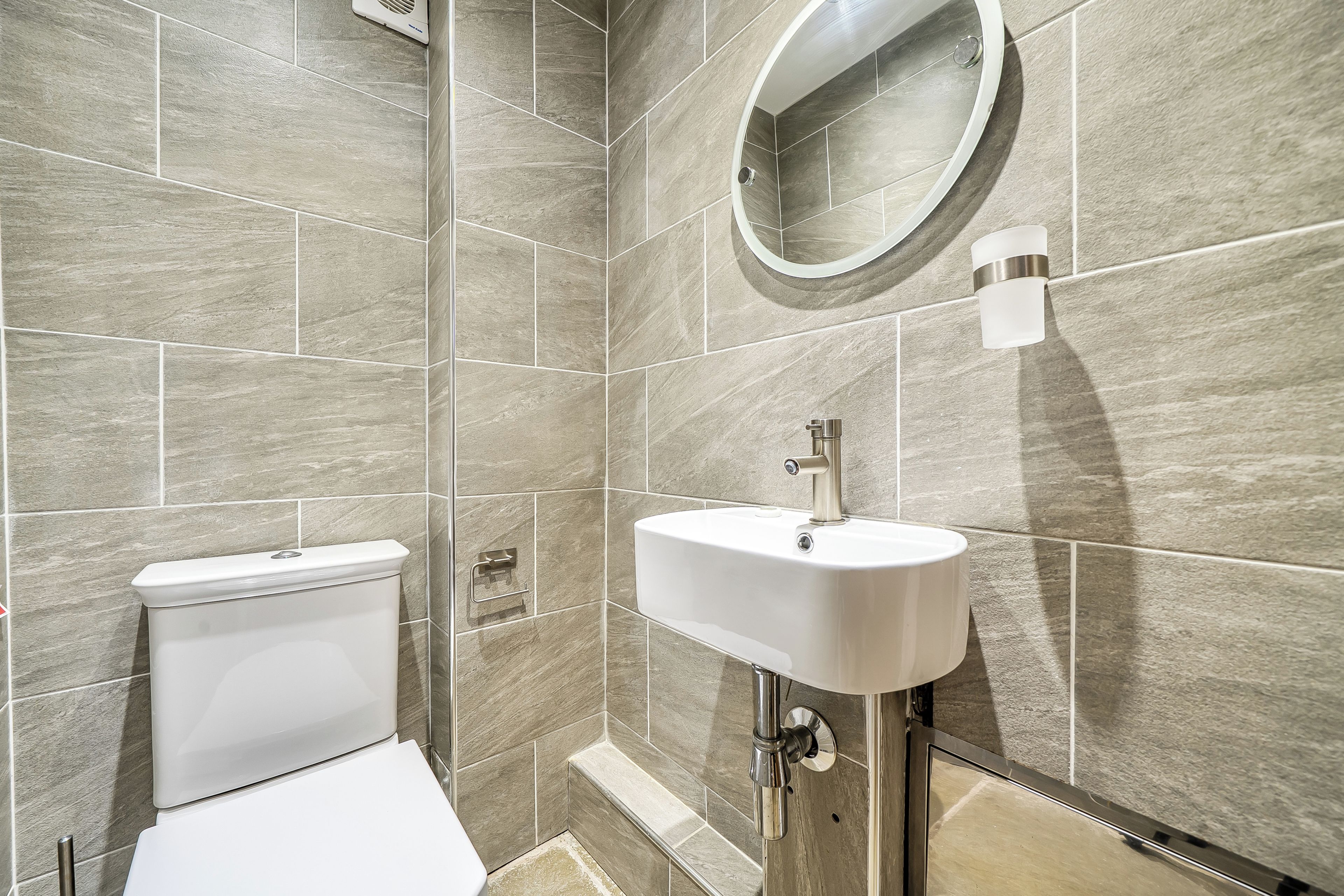 A bathroom with a toilet, sink, and shower area.