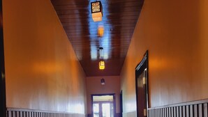 A hallway with wooden paneling, a tiled floor, and a hanging light fixture. - Stylia Suites (Dalhousie)