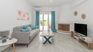 Een moderne woonkamer met een bank, een salontafel, een open haard en een televisie.