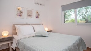 Een slaapkamer met een bed, nachtlampjes, een raam en wanddecoratie.