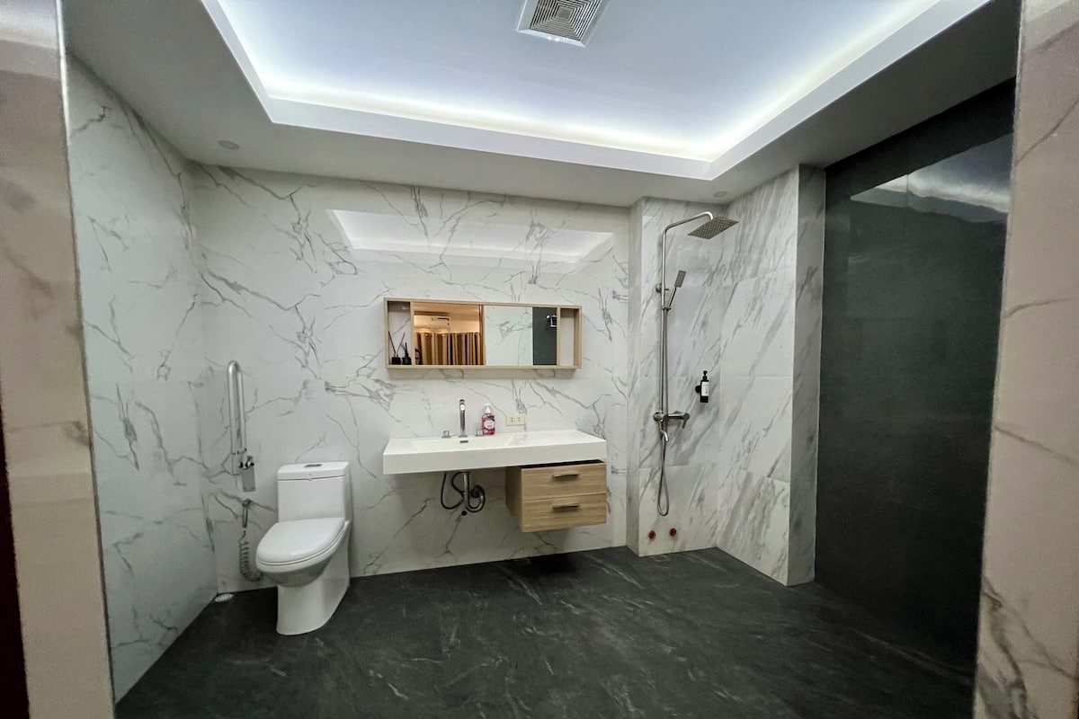 Familiekamer | Badkamer | Een douche, een haardroger, handdoeken, zeep