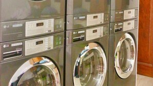 A row of LG commercial-grade front-loading washing machines in a facility. - Casa Ison Hotel (Sablayan)