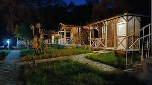 A rustic cabin-style hotel with a stone pathway leading to the entrance, surrounded by greenery. - Angels Garden Hotel (Kumluca)