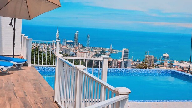 A balcony with a pool, a city view, and a beach. - GOLDEN SUNSET batumi  (Batumi)