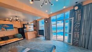 A modern bedroom with a large bed, a desk, and a view of the ocean. - GOLDEN SUNSET batumi  (Batumi)