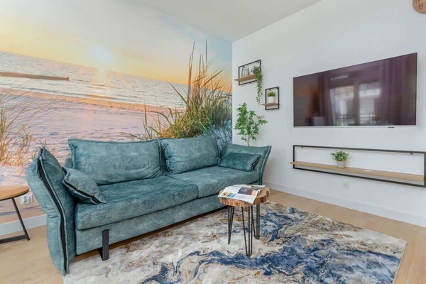 A spacious living room with a comfortable seafoam sofa, ideal for relaxing after a busy day.