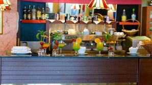 A bar area with a counter displaying various drinks, a shelf with bottles, and a visible cash register. - Hôtel Abbasside Palace - Palm Beach (Algiers)