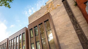 Een modern gebouw met grote ramen en een bord waarop 
