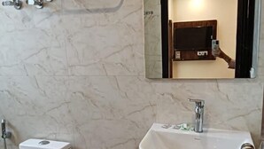 Un baño con inodoro, lavamanos y espejo.