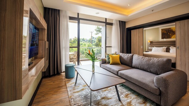 Un salon moderne avec un canapé, une table basse et un téléviseur fixé au mur.
