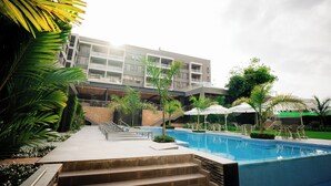 Un hôtel moderne doté d’une piscine, d’un espace extérieur aménagé et d’un escalier menant à la zone de la piscine.