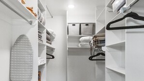 A walk-in closet with white shelving, a hanging rod, and a wooden floor. - War Eagle Creek Retreat- Cabin on the Creek- Private but close to everything (HUNTSVILLE)