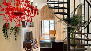 Ein modernes Interieur mit Treppe, Essbereich und Wohnraum mit Fernseher und Sitzgelegenheiten.