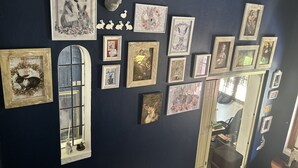 Una pared decorada con varias fotografías enmarcadas y una cabeza de conejo montada.