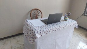 A small table with a laptop, a notepad, and a cup with pens. - Hotel O Wunut Homestay Syariah (Sidoarjo)