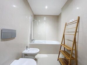 A modern bathroom with a bathtub, a pedestal sink, and a wooden shelf. - The View by Atlantic Holiday (Funchal)