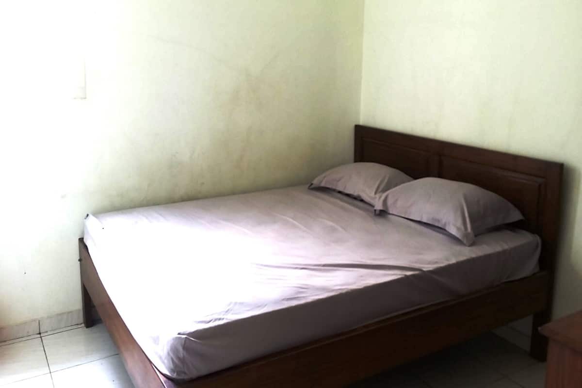 A single bed with a wooden frame and a white mattress.
