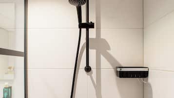 Une douche moderne dotée d’un pommeau de douche à main et d’un panneau de commande fixé au mur.