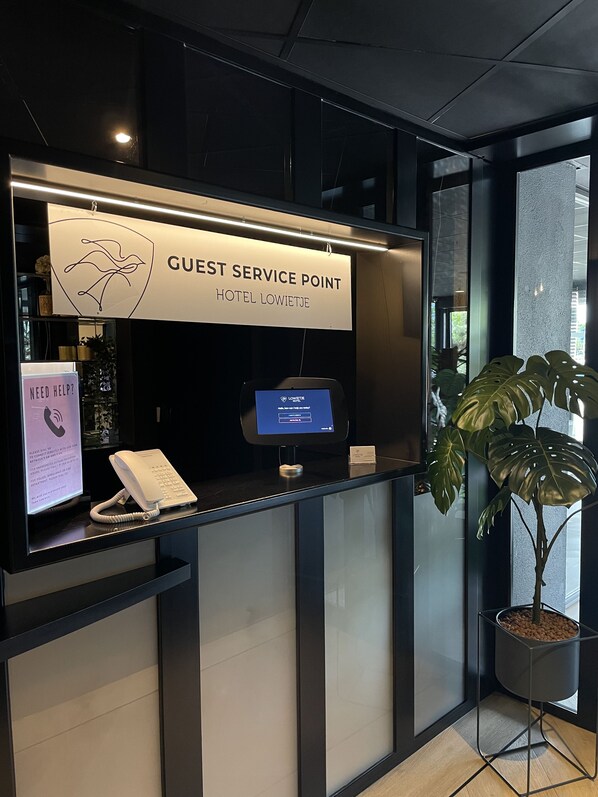 A guest service point with a digital screen, a phone, and a sign indicating the hotel name. - Hotel Lowietje Lisse - Keukenhof (Lisse)