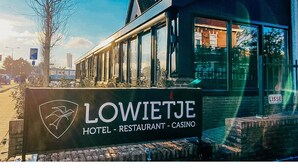 Hotellin kyltti, jossa on logo ja teksti: ”LOWIETJE HOTEL – RESTAURANT – CASINO”.