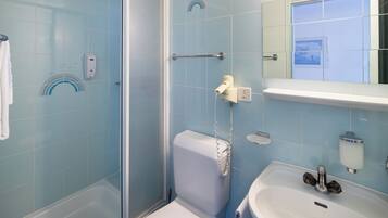 A bathroom with a shower, toilet, and sink.