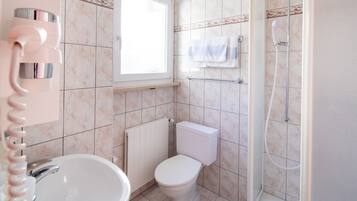 Un baño con inodoro, lavamanos y ducha.