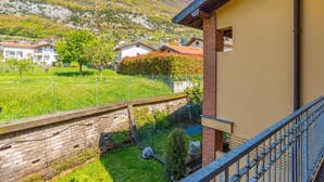 A residential area with houses, a grassy yard, and a mountain in the background. - Lenno Glamour (Tremezzina)
