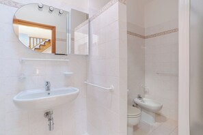 A bathroom with a sink, mirror, and toilet. - Lenno Glamour (Tremezzina)