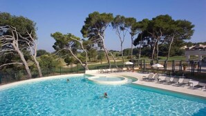 A swimming pool with a circular hot tub, surrounded by lounge chairs and trees. - La Calade, in the heart of Provence Country Club (Saumane-de-Vaucluse)