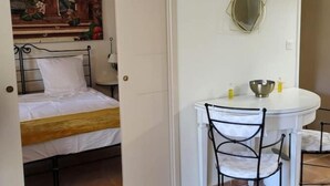 A bedroom with a bed, a painting, a small table with chairs, and a mirror on the wall. - La Calade, in the heart of Provence Country Club (Saumane-de-Vaucluse)