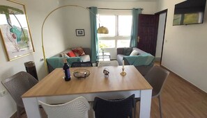 Cozy living space with a dining table, sofa, and artwork.