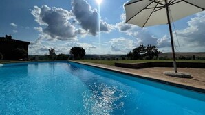 A swimming pool with a clear sky and a sun shining.