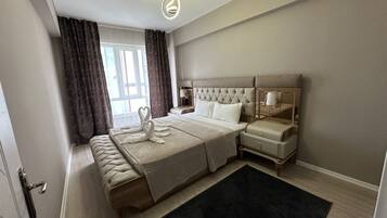 Une chambre d’hôtel moderne avec un grand lit, un banc, une table de chevet et un miroir.