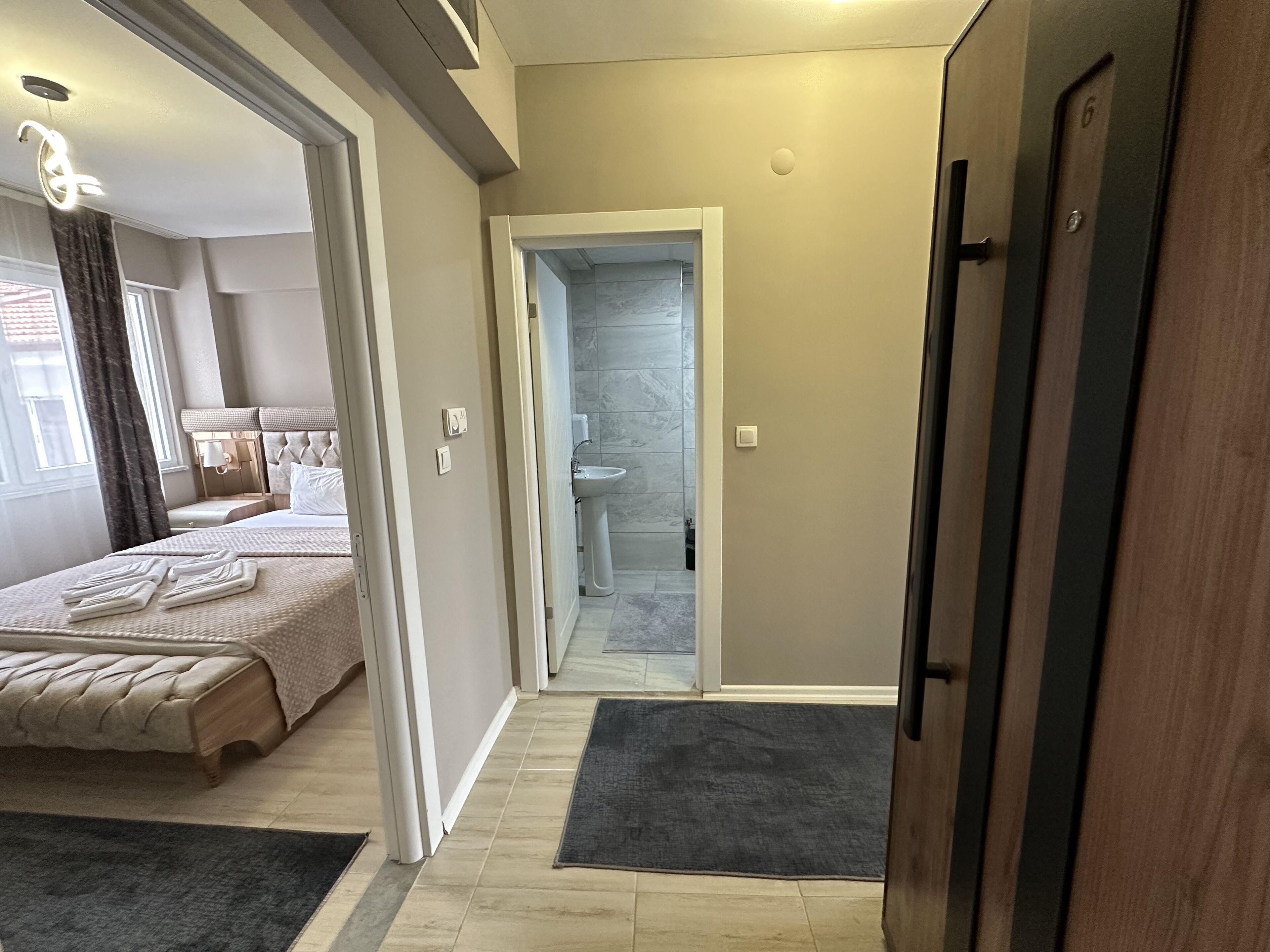 Ein Hotelzimmer mit Bett, Badezimmer und Tür.