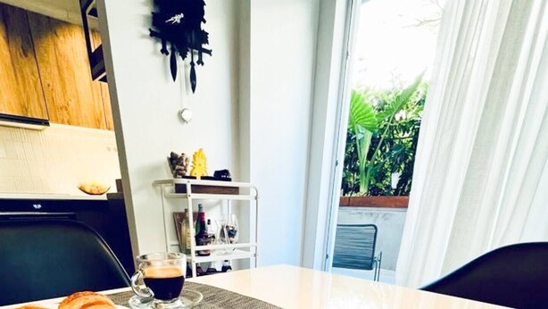 A dining table with croissants, a book titled 'Walking in Athens', and a coffee cup. - Athenian Coastal Urban Living (Paleo Faliro)