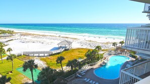 Een resort met zwembad, strand en uitzicht op de oceaan.