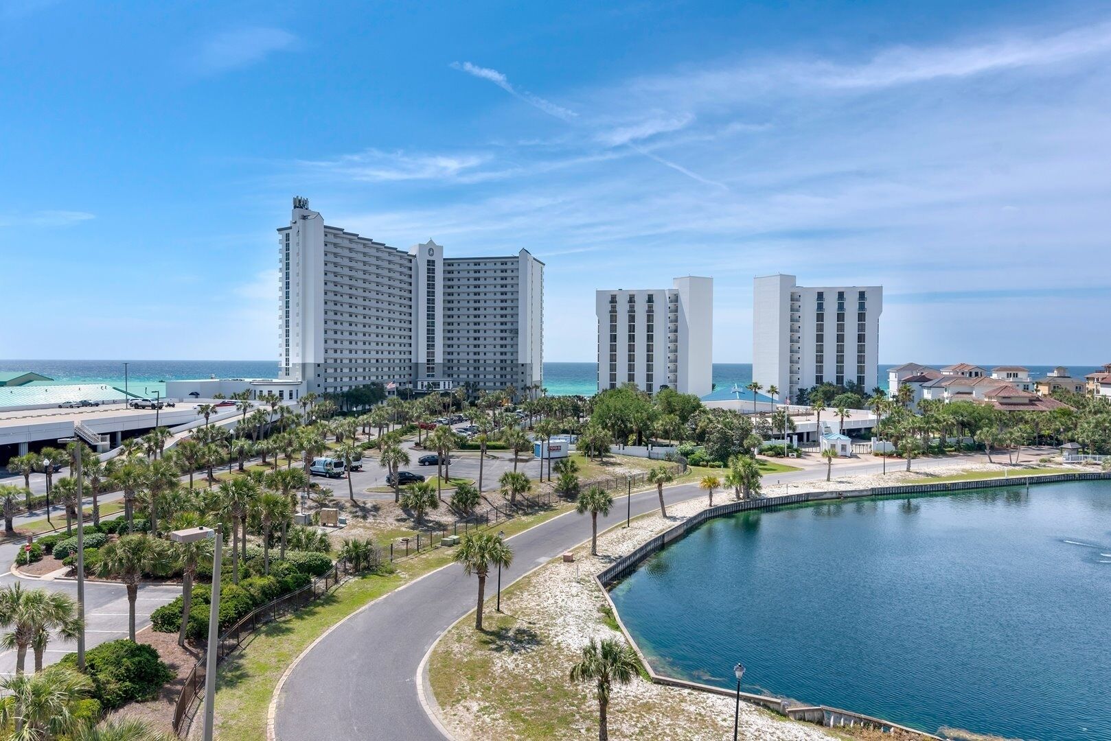 Ein K üstenhotel mit mehreren Hochhäusern, einer Marina und einer gewundenen Straße, die zum Strand führt.
